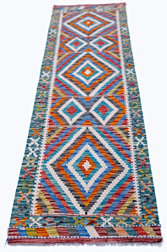 A handmade Afghan Maimana wool runner rug featuring a vibrant geometric diamond pattern.
