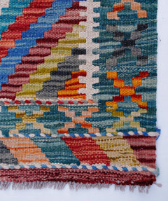 Handwoven Afghan Maimana kilim runner featuring a vibrant geometric pattern in wool.