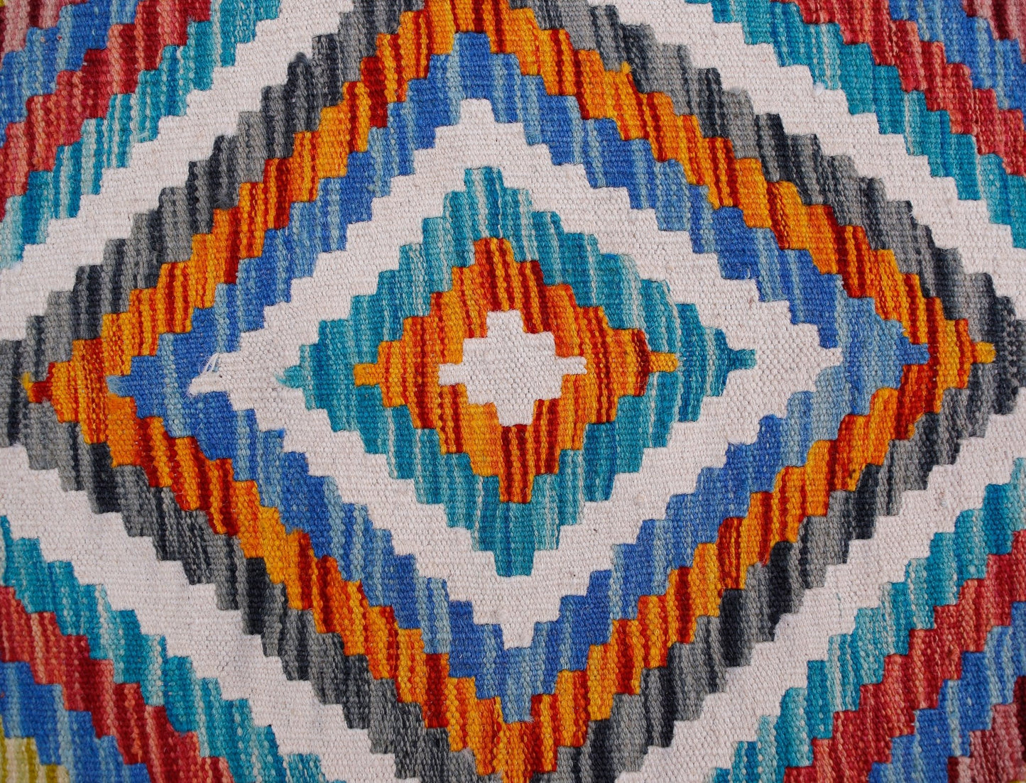 A handmade Afghan Maimana kilim runner featuring a vibrant geometric diamond pattern in wool.
