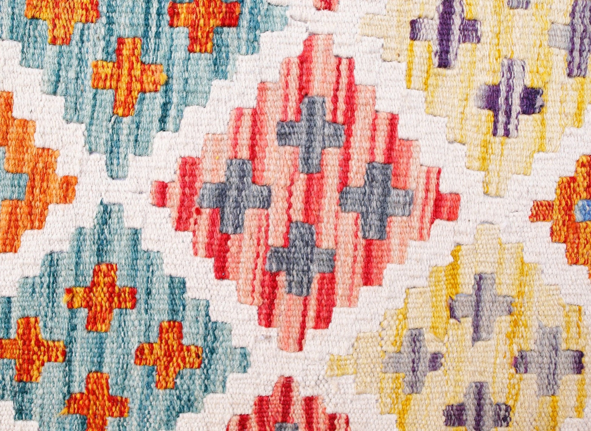 Handwoven wool kilim runner featuring a geometric diamond pattern in blue, red, and yellow.
