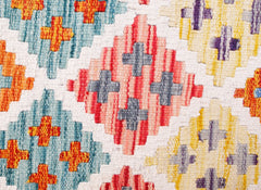 Handwoven wool kilim runner featuring a geometric diamond pattern in blue, red, and yellow.