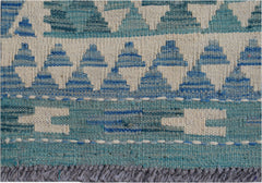 A handmade Afghan Maimana wool kilim runner featuring a geometric pattern in shades of blue.