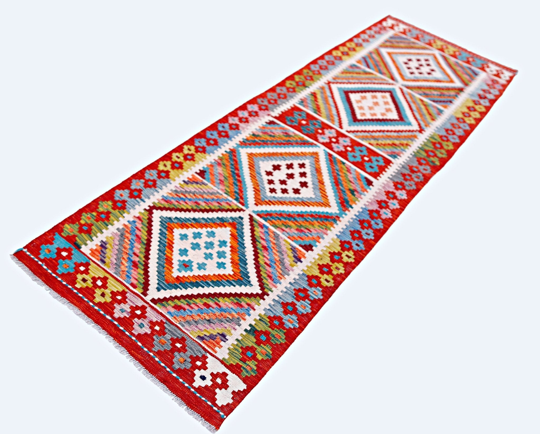 A handmade Afghan Maimana wool runner rug featuring a vibrant geometric diamond pattern.