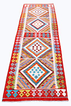 A handmade Afghan Maimana wool runner rug featuring colorful geometric diamond patterns.