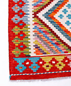 Handwoven Afghan Maimana wool runner featuring a vibrant geometric pattern in red and multi-colors.
