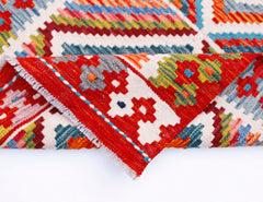 A handmade Afghan Maimana wool kilim runner featuring a vibrant geometric pattern.