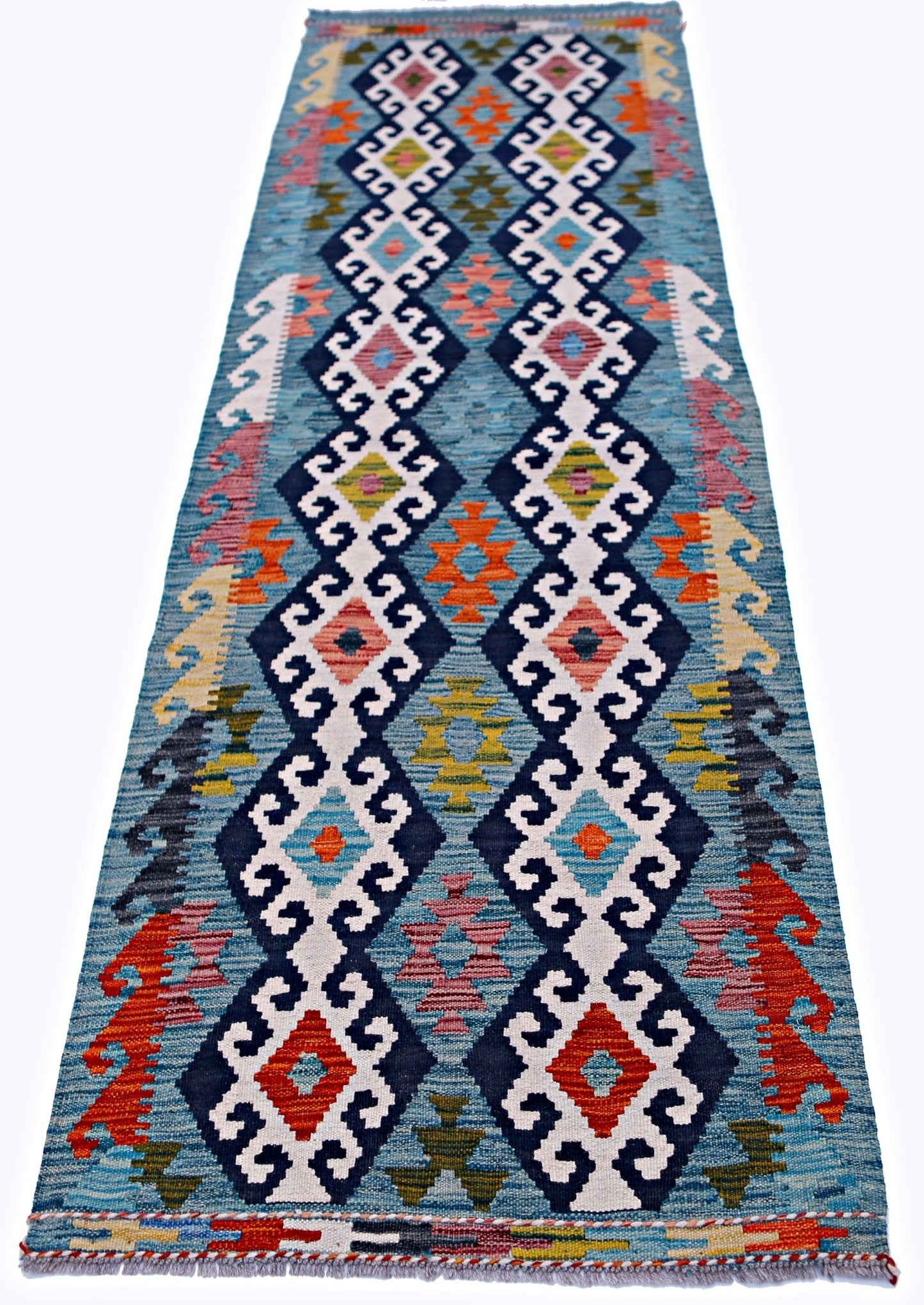 Handwoven Afghan Maimana wool runner rug featuring a blue background with geometric patterns.
