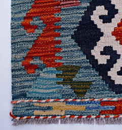 A close-up of a handmade Afghan Maimana kilim runner featuring geometric patterns in wool.