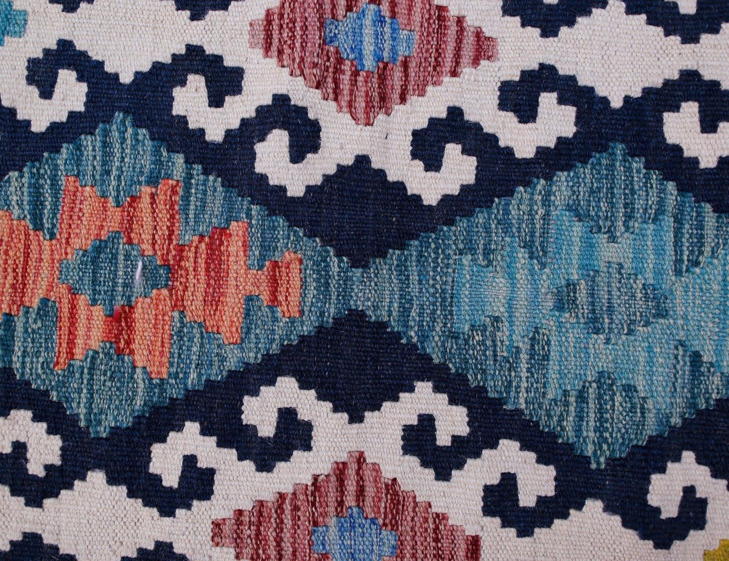 Handwoven Afghan Maimana kilim runner featuring a geometric pattern in blue, red, and cream wool.