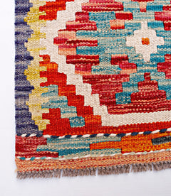 Handwoven Afghan Maimana wool runner featuring a vibrant geometric pattern and fringed edges.