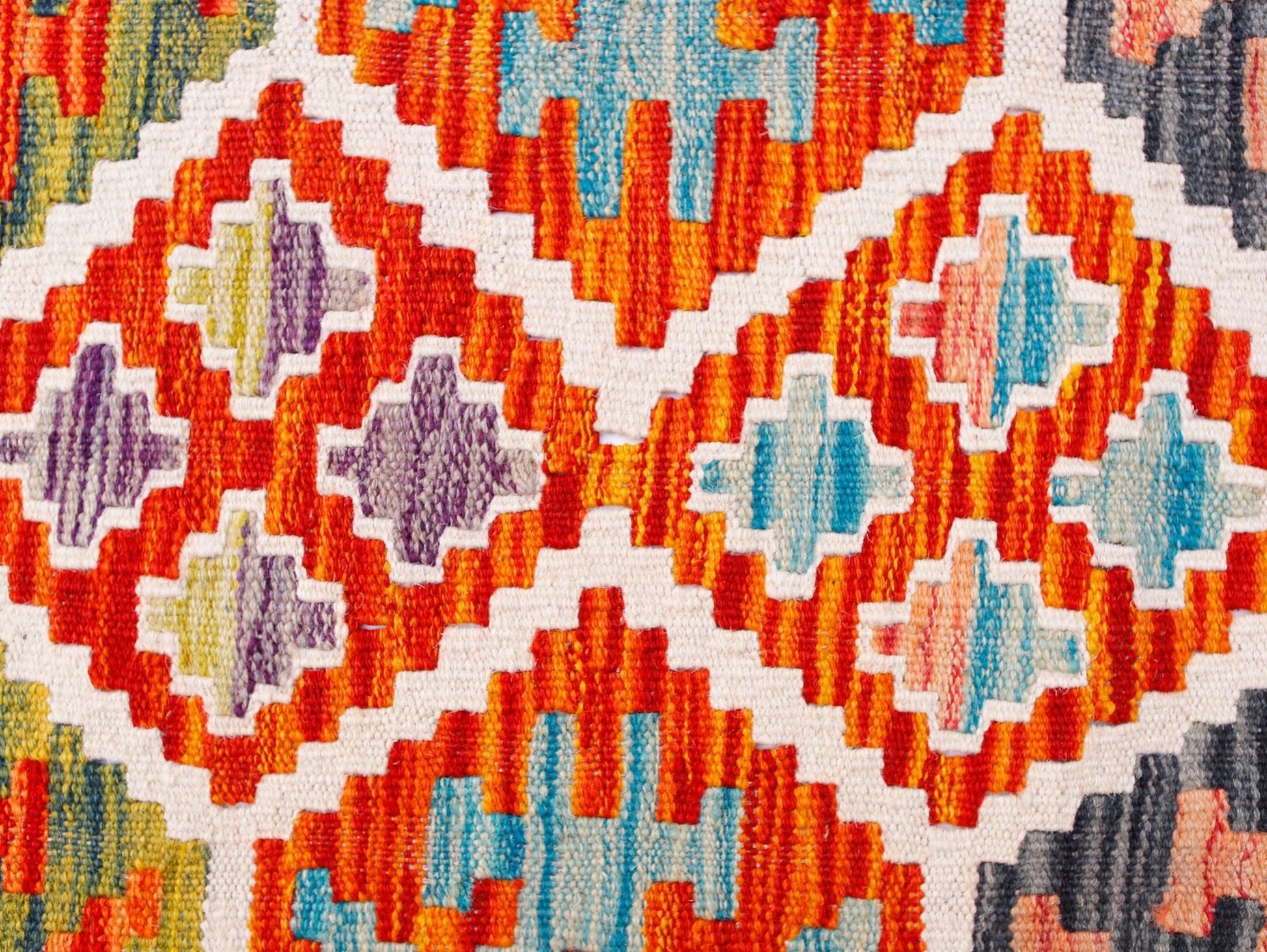 Handwoven Afghan Maimana kilim runner featuring a vibrant geometric pattern in wool.