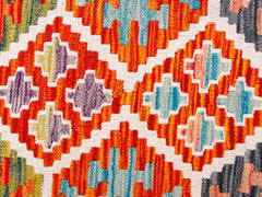Handwoven Afghan Maimana kilim runner featuring a vibrant geometric pattern in wool.