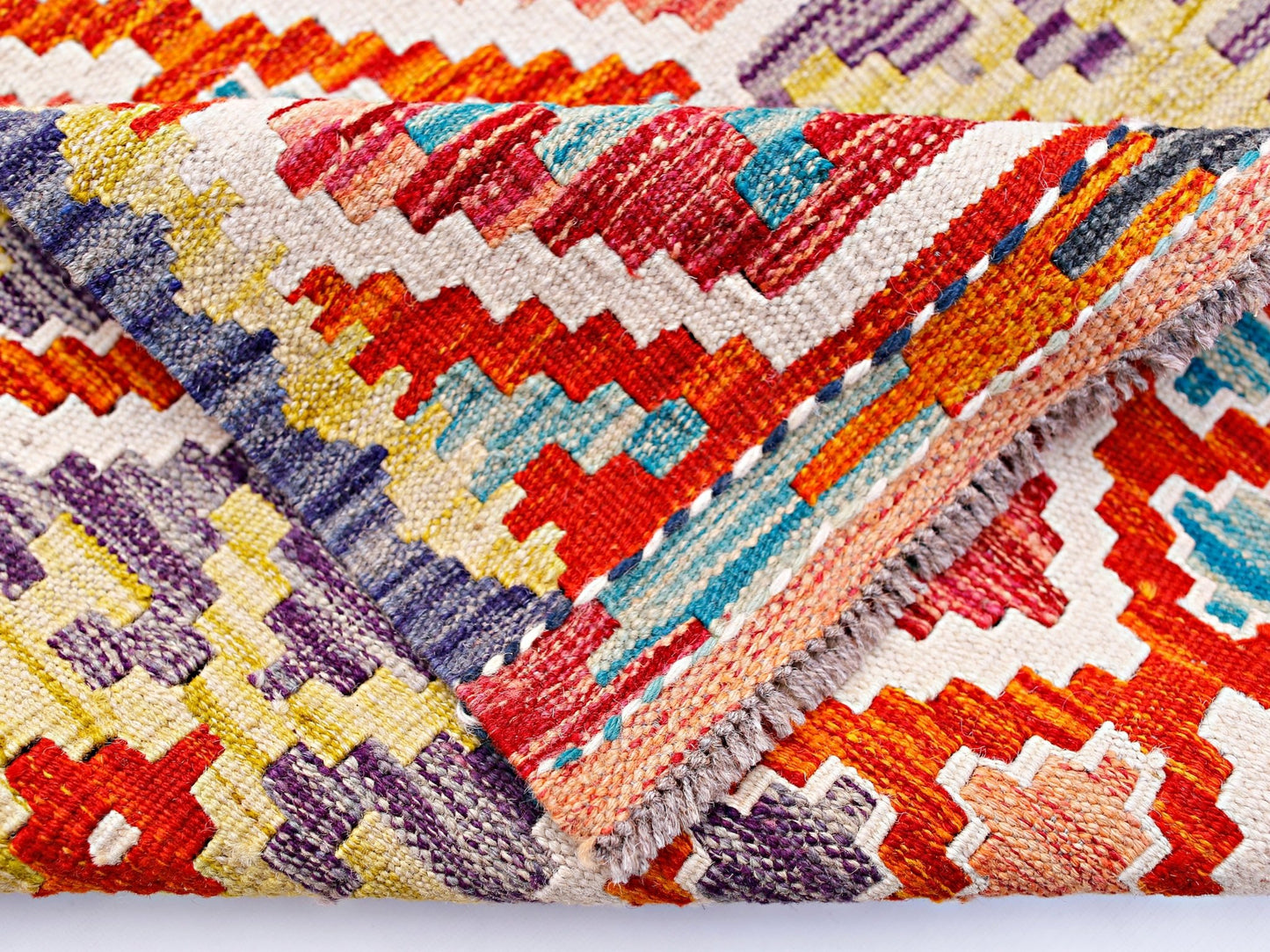 A handwoven wool kilim runner featuring a vibrant geometric pattern in red, blue, and yellow.