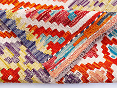 A handwoven wool kilim runner featuring a vibrant geometric pattern in red, blue, and yellow.