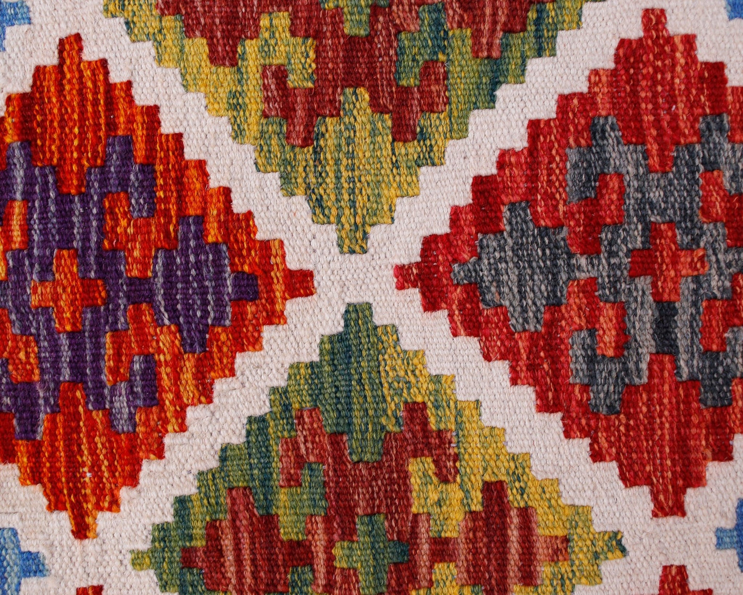 A handmade Afghan Maimana kilim runner featuring a geometric pattern in vibrant wool colors.