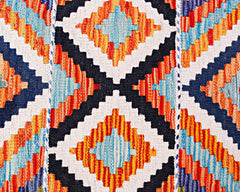 Handwoven wool runner featuring a geometric diamond pattern in vibrant orange, blue, and white.