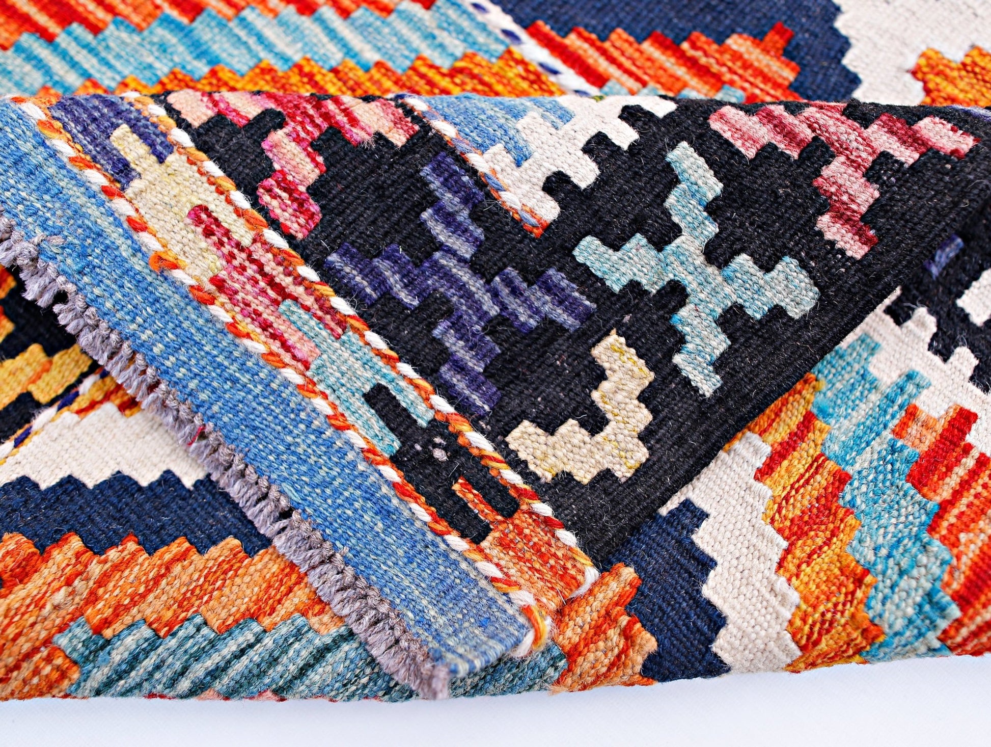 A handwoven Afghan Maimana kilim runner featuring a vibrant geometric pattern in wool.