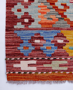 Handwoven Afghan Maimana kilim runner featuring geometric patterns in vibrant wool colors.