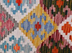 A handmade Afghan Maimana kilim runner featuring a vibrant geometric pattern in wool.
