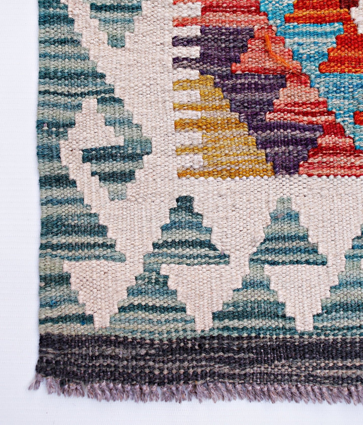 Handwoven Afghan Maimana wool runner featuring a geometric pattern in teal, red, and yellow.