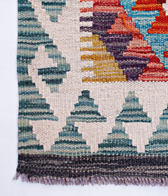 Handwoven Afghan Maimana wool runner featuring a geometric pattern in teal, red, and yellow.