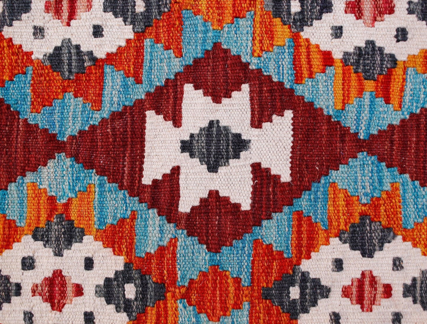 Handwoven Afghan Maimana kilim runner featuring a vibrant geometric pattern in wool.
