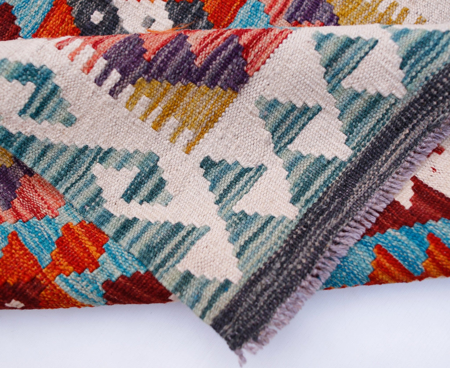 A handmade Afghan Maimana wool kilim runner featuring a colorful geometric pattern.