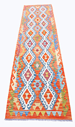 Handwoven Afghan Maimana wool runner featuring a vibrant orange background and geometric patterns.