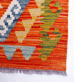 Handwoven Afghan Maimana wool kilim runner featuring a vibrant geometric pattern.