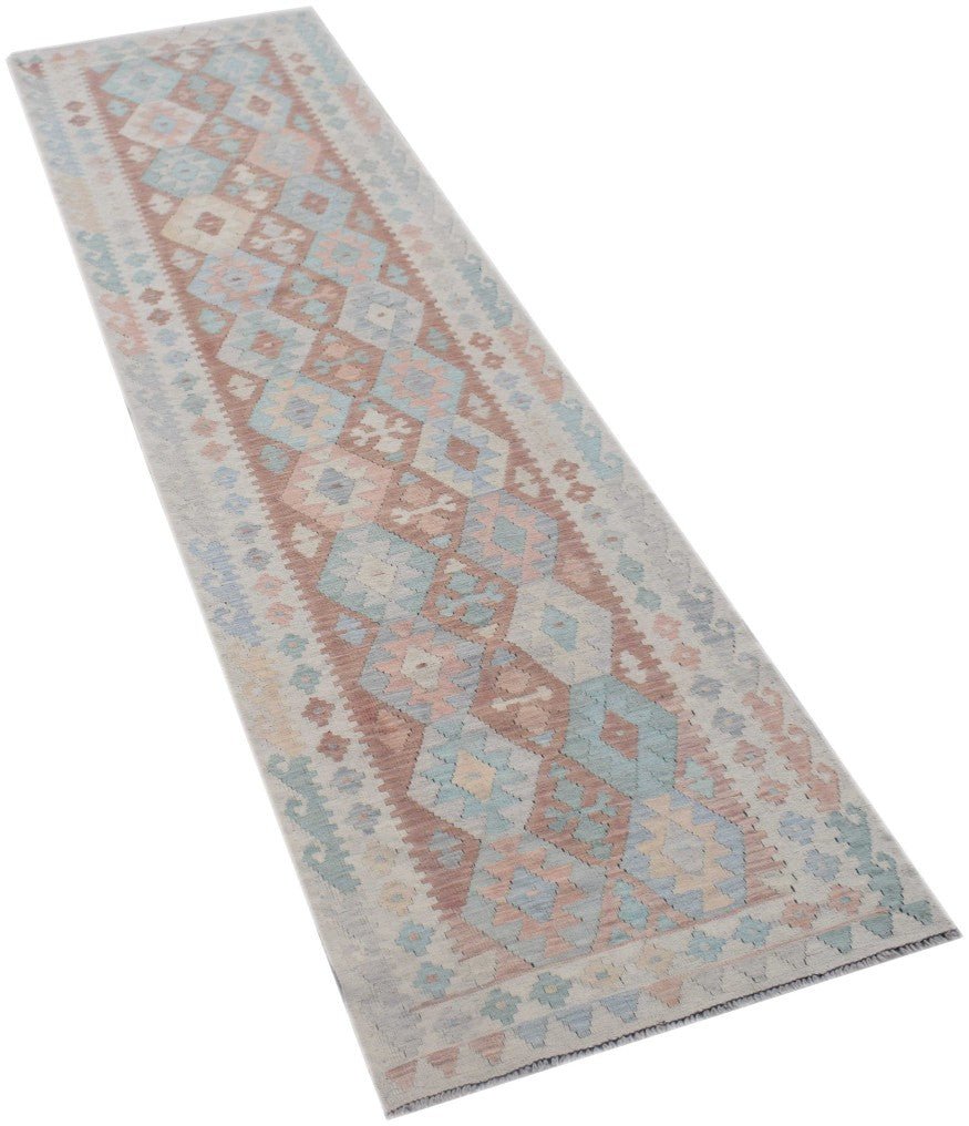 A handmade Afghan Maimana Kilim runner featuring a geometric pattern in soft blue and pink tones.