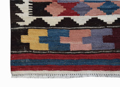 A handmade Afghan Maimana kilim runner featuring geometric patterns in vibrant wool colors.