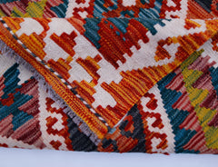 A handwoven Afghan Maimana kilim runner featuring a vibrant geometric pattern in wool.