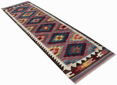 An Afghan Maimana Kilim runner featuring a colorful geometric diamond pattern on a flatweave wool.