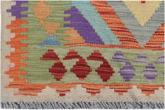 A handmade Afghan Maimana kilim runner featuring colorful geometric patterns on a wool base.