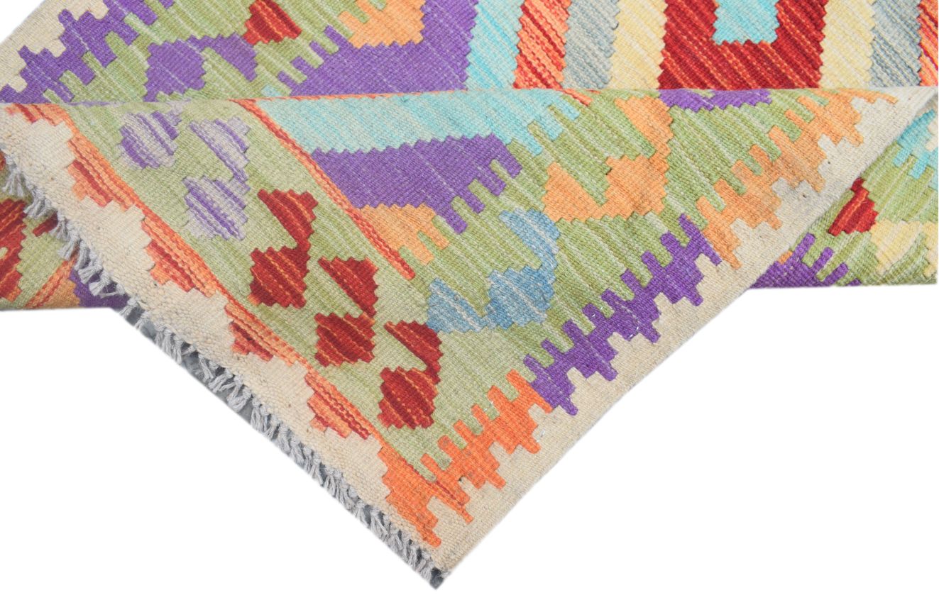 A handmade Afghan Maimana kilim runner featuring vibrant geometric patterns in wool.
