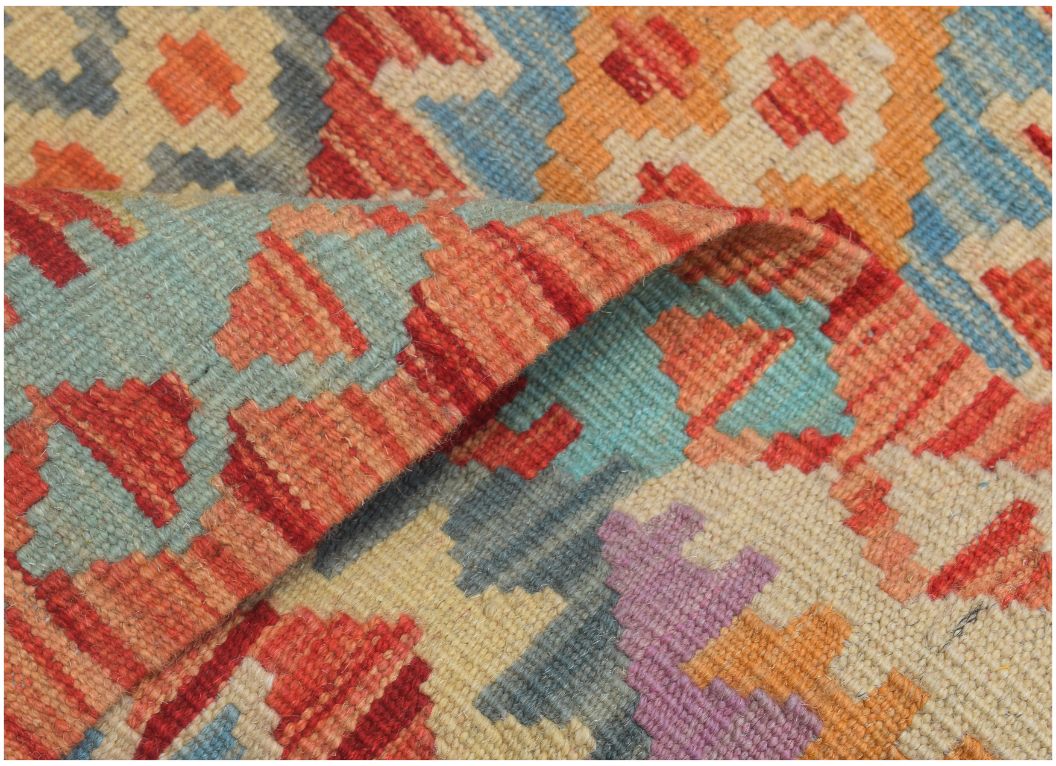 A handmade Afghan Maimana kilim runner featuring a geometric pattern in vibrant, multicolored wool.