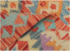 A handmade Afghan Maimana kilim runner featuring a geometric pattern in vibrant, multicolored wool.