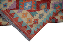 A handmade Afghan Maimana kilim runner featuring colorful geometric patterns and fringed edges.