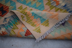 Handwoven Afghan Maimana wool kilim runner featuring a geometric pattern in vibrant colors.