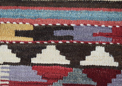 A close-up of a handmade Afghan Maimana wool kilim runner featuring geometric patterns and colors.