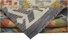 A folded Afghan Maimana kilim runner featuring a geometric pattern in orange, blue, and grey wool.