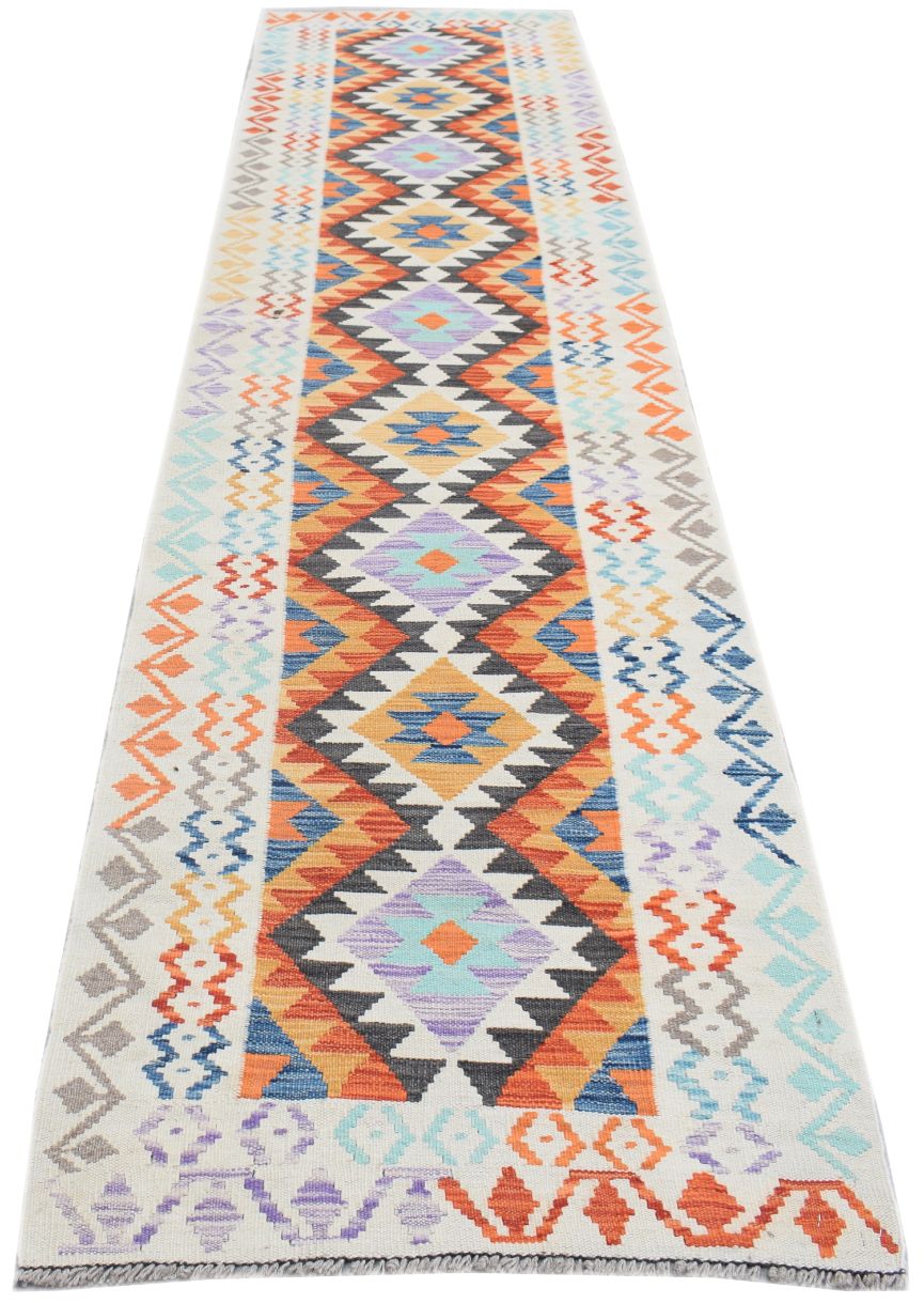 A handmade Afghan Maimana wool runner rug featuring a vibrant geometric pattern in multi-colored hues.