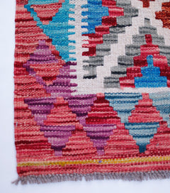 Handwoven Afghan Maimana wool runner featuring a vibrant geometric pattern in red, blue, and purple.