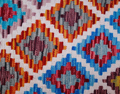 Handwoven wool kilim runner featuring a repeating geometric diamond pattern in vibrant colors.