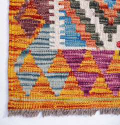 A handmade Afghan Maimana kilim runner featuring vibrant geometric patterns in wool.
