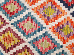 Handwoven wool kilim runner featuring a colorful geometric diamond pattern on a white background.