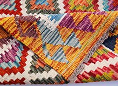 A handwoven Afghan Maimana kilim runner featuring a vibrant geometric pattern in wool.