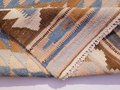 A handwoven Afghan Maimana kilim runner featuring geometric patterns in blue, brown, and cream.