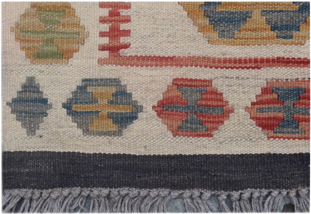 Handmade Afghan Maimana kilim runner featuring geometric patterns in earthy tones and a fringe edge.