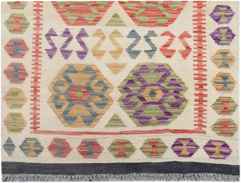 Handmade Afghan Maimana kilim runner featuring colorful geometric patterns on a cream background.